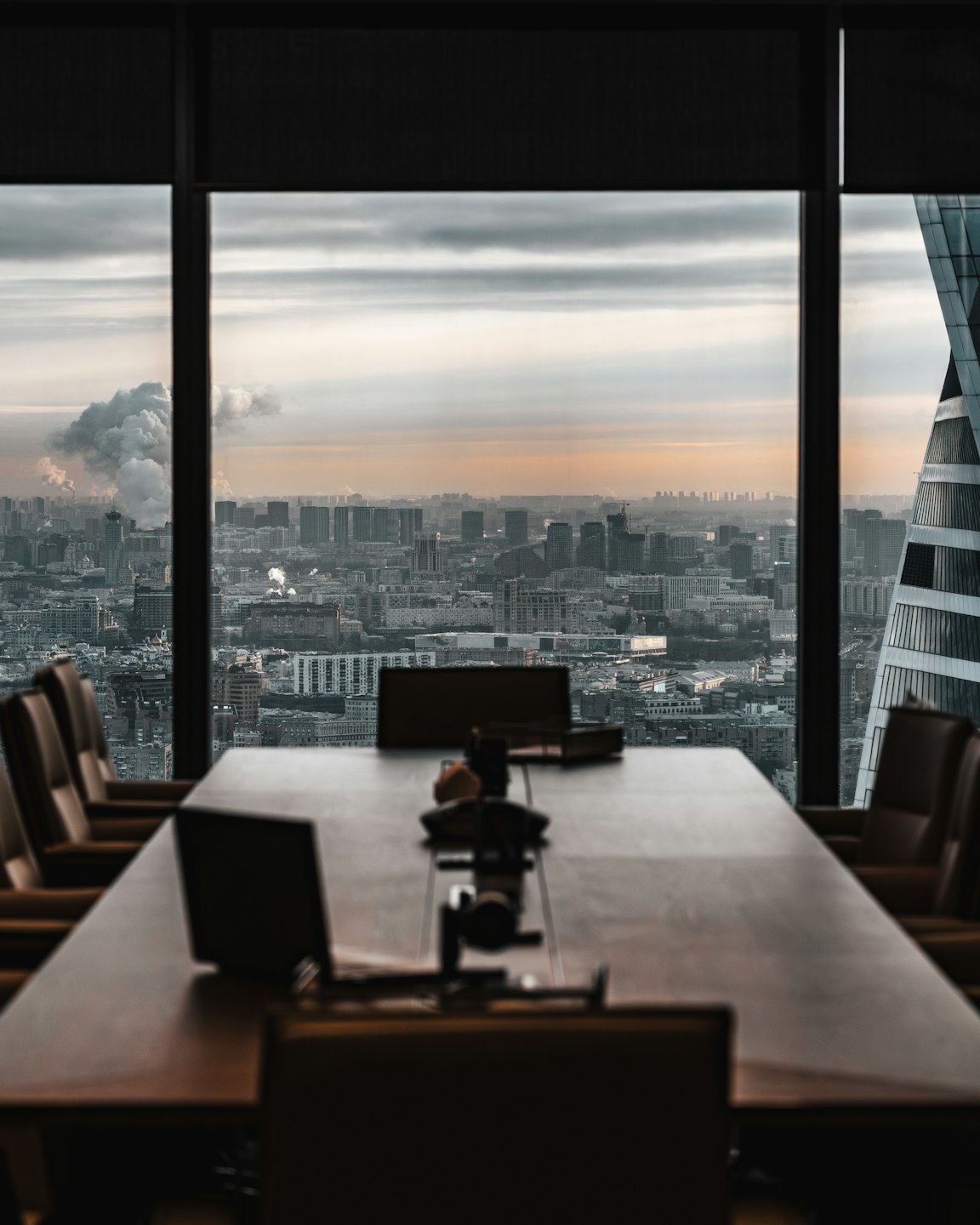 Leerer Konferenzraum mit Stadtblick durch große Fenster.